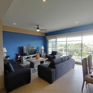 a living room with two couches and a tv at Mayan Lake Horus in Acapulco