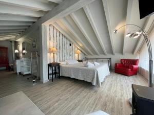 ein Schlafzimmer mit einem Bett und einem roten Stuhl in der Unterkunft La Posada de Langre Anexo in Langre