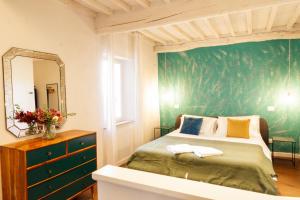 - une chambre dotée d'un lit avec un mur vert dans l'établissement Incanto b&b, à Pienza