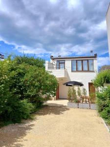 een wit huis met een bankje ervoor bij Dunes et Mer - Terrace, garden and free parking space in Oostende