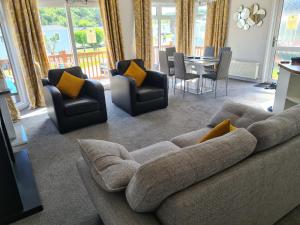 uma sala de estar com um sofá, cadeiras e uma mesa em Mildreds Lodge with Hot Tub em Felton