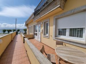 a patio with a table and chairs on a balcony at Apartamento en Playa Rapadoira in Foz