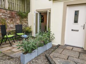 a front door of a house with a table and chairs at Herdwick Cottage in Brampton