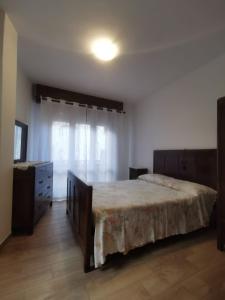 a bedroom with a bed and a dresser and a window at Tiny House Dolomiti in Sovramonte