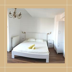 um quarto com uma cama branca com um objecto amarelo em Pristina newborn rooms em Pristina