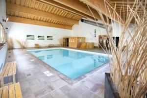 duży basen w dużym pokoju z drewnianymi sufitami w obiekcie Le Hameau SPA & PISCINE studio 2 pers by Alpvision Residences w mieście Orelle