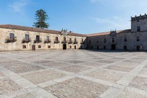 an empty courtyard of an old building with a tree at Charm apartment in Cambados