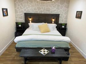 Schlafzimmer mit einem großen Bett mit einem Kopfteil aus Holz in der Unterkunft Villa di Casa - Boutique Hotel in Wellington