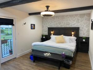 a bedroom with a bed with a stone wall at Villa di Casa - Boutique Hotel in Wellington