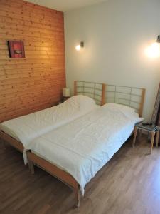 een groot bed in een kamer met een houten muur bij Le Hameau SPA & PISCINE studio 2 pers by Alpvision Residences in Orelle