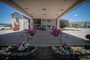 una vista frontal de un edificio con flores púrpuras y blancas en Clover Creek Inn en Montpelier