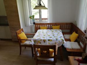 a dining room with a table with yellow cushioned chairs at Apartment Hörmann in Ardning