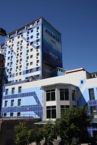 un grand bâtiment avec un panneau sur son côté dans l'établissement Hotel Avanta, à Vladivostok