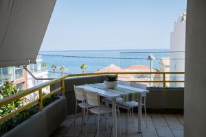 stół i krzesła na balkonie z widokiem na ocean w obiekcie Eftihia Apartments by the sea w Retimnie