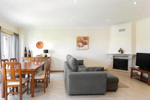 a living room with a table and a couch and a television at Óbidos Garden Villa in Óbidos