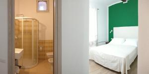 a hotel room with a bed and a shower at Hotel Da Cecco in Santa Teresa Gallura
