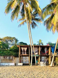 ein Haus am Strand mit zwei Palmen in der Unterkunft Calma Chicha in Santa Marta