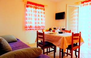 ein Esszimmer mit einem Tisch und Stühlen mit Weingläsern in der Unterkunft Apartments Graciela in Lastovo