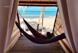 a hammock in a room with a view of the beach at Calma Chicha in Santa Marta