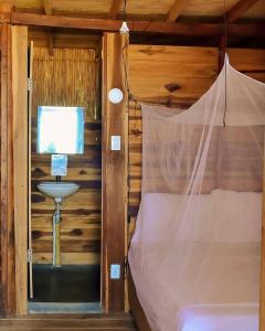 ein Schlafzimmer mit einem Bett in einer Holzhütte in der Unterkunft Calma Chicha in Santa Marta