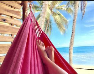 a person laying in a hammock on a beach at Calma Chicha in Santa Marta