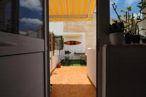 an open door to a kitchen with a surfboard on the wall at Surf Vibe Guest House in Faro