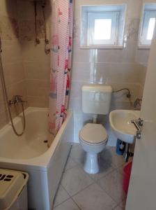 een badkamer met een toilet, een bad en een wastafel bij Apartment Perica - 10 m from sea in Postira
