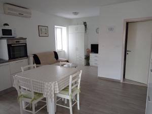 een keuken en eetkamer met een tafel en stoelen bij Apartment Perica - 10 m from sea in Postira