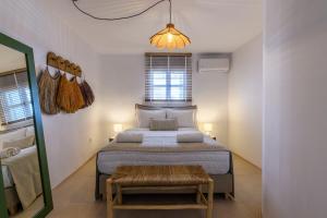 1 dormitorio con 1 cama grande y espejo en Ikos residence en Mykonos