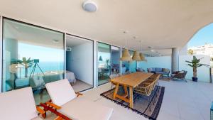 salon z drewnianym stołem i krzesłami w obiekcie Stupa Hills IV F33G - Superb Sea View Apartment w mieście Benalmádena