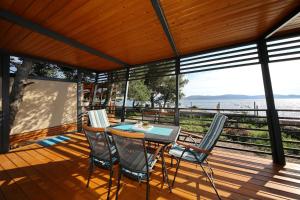 a table and chairs on a deck with a view of the water at Mobile home Safir in Biograd na Moru