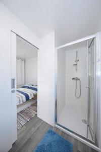 a white bathroom with a shower with a mirror at Mobile home Safir in Biograd na Moru