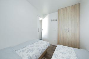a bedroom with a bed and a wooden cabinet at Mobile home Safir in Biograd na Moru
