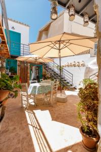 a patio with a table and an umbrella at Santa Napa Guest House in Famagusta
