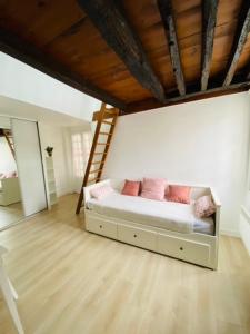 a bedroom with a bed with pink pillows and a ladder at Paris Louvre in Paris