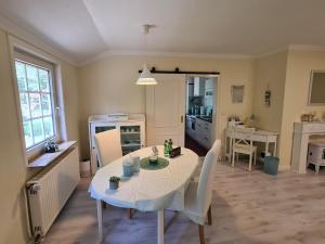 a kitchen and dining room with a table and chairs at Das Weisse Haus Bockholt in Soltendieck