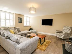 a living room with a couch and a tv at The Coach House in Tetbury