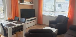 TV a/nebo společenská místnost v ubytování Residenz am Strand Wohnung 4-59