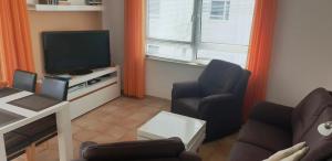 TV a/nebo společenská místnost v ubytování Residenz am Strand Wohnung 4-59