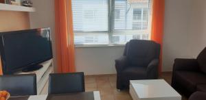 TV a/nebo společenská místnost v ubytování Residenz am Strand Wohnung 4-59