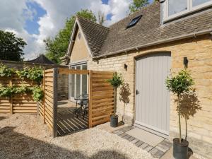 a garden with a white garage door and a patio at The Hayloft in Tetbury