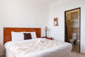 a bedroom with a bed with a stuffed animal on it at Hacienda Margarita in Barranquitas