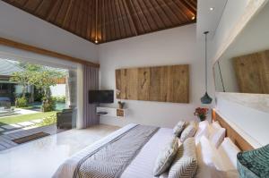 a bedroom with a bed and a tv in it at Villa Sanook in Seminyak