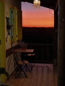 a balcony with chairs and a view of a sunset at Sítio Juara in Santa Teresa