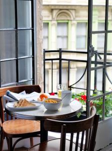 a table with a plate of food on a balcony at Grand Hotel Sydney in Sydney