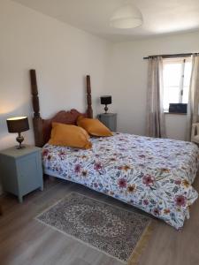 a bedroom with a bed with a floral comforter at Butterfly Cottage in Chaunay