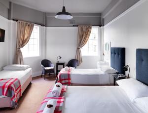 雪梨的住宿－悉尼大酒店，一间卧室配有两张床和一张桌子及椅子