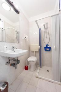 La salle de bains est pourvue d'un lavabo, de toilettes et d'une douche. dans l'établissement Monolocale Salento, à Galatone