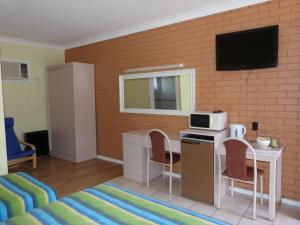 a living room with a table and a microwave at Fullarton Motor Lodge in Adelaide