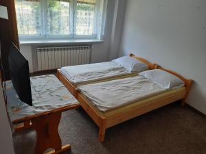 ビャウカにあるPokoje Gościnne u Moniのベッドルーム1室(ベッド2台、テーブル上のテレビ付)